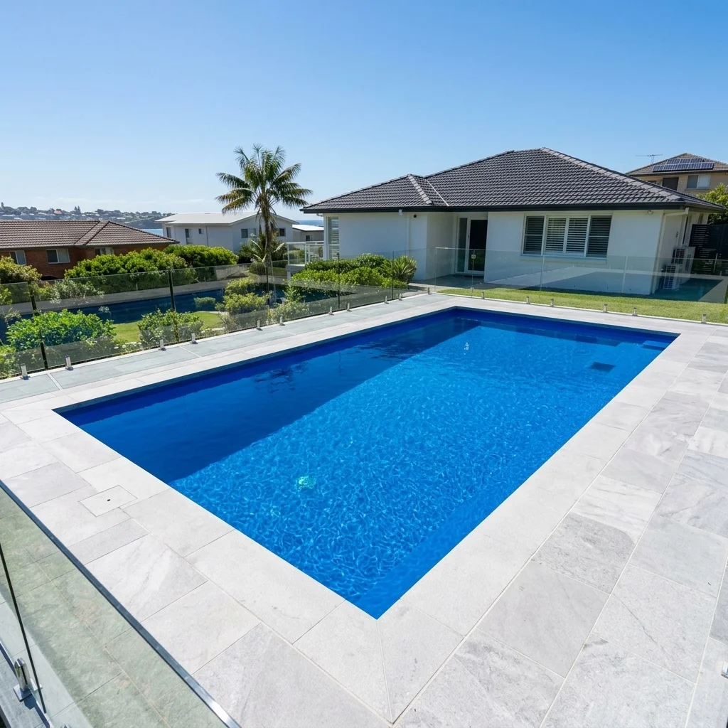 Wide shot of a freshly painted, vibrant blue residential pool on a sunny Sydney day, clean water, sharp edges